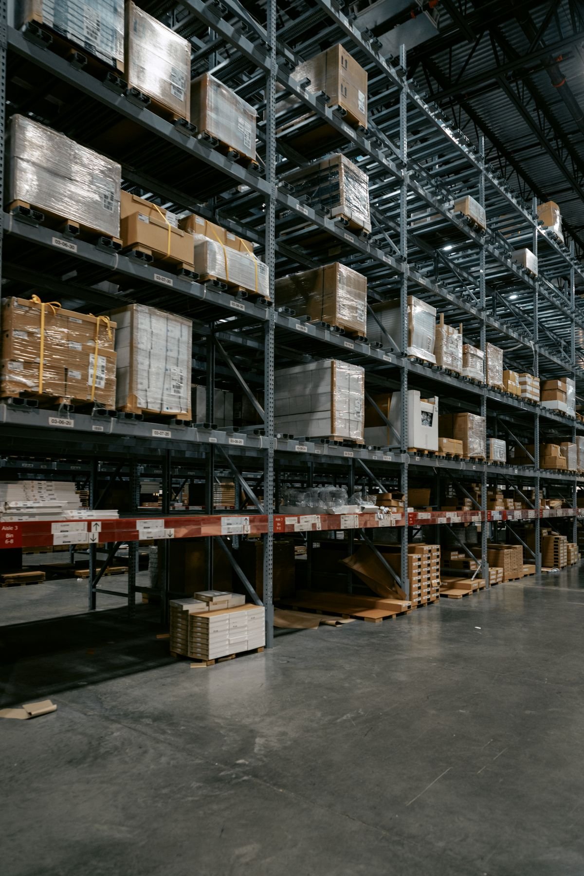 Warehouse racking stacked with wrapped pallets and boxes
